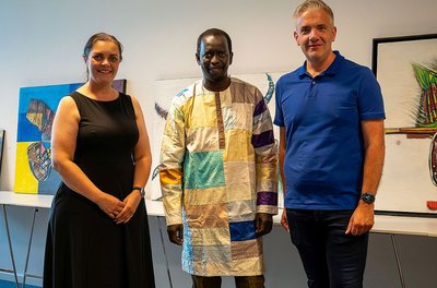 Kathrin de Blois, Taha Diakhaté und Alexander de Blois | Foto unten: Taha Diakhaté im Gespräch mit Besucherinnen der Vernissage | Fotos: © Haaß GmbH & Co. KG